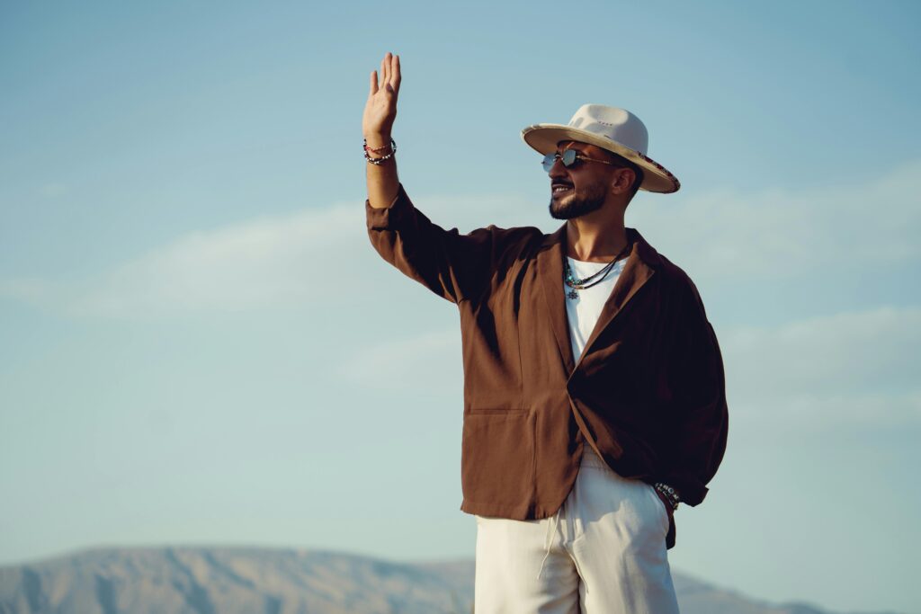 Trendy man wearing hat and sunglasses, enjoying sunny day in nature.